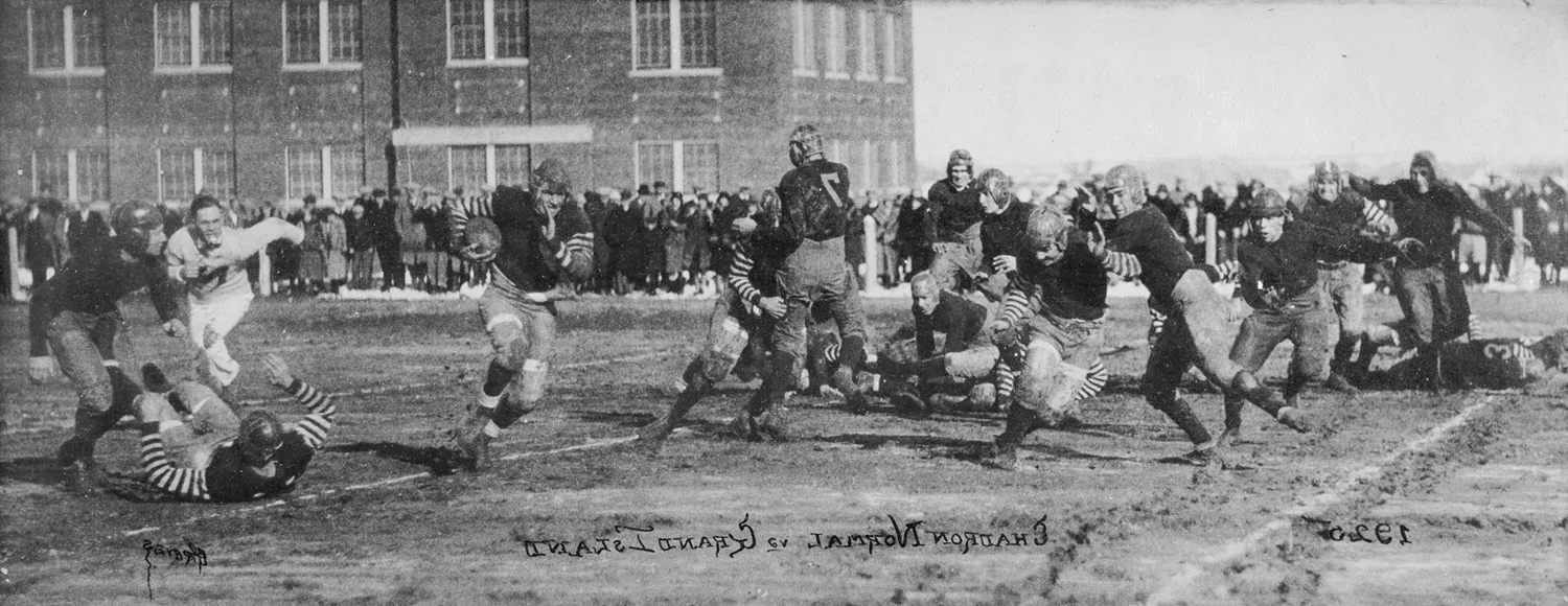 Football player running the ball, surrounded by offense and defense